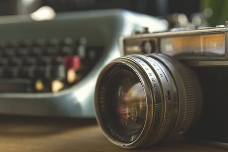 Old film photocamera and vintage blue typewriterの写真素材