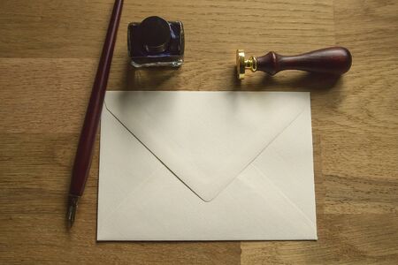 Blank envelope, fountain pen, seal and ink on the wooden deskの写真素材