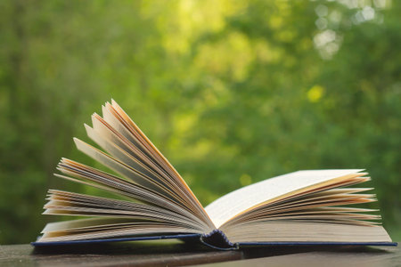 Open book on garden wooden table