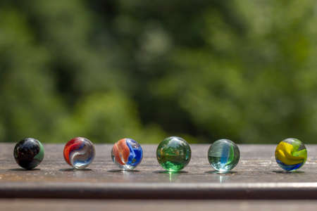Colorful marbles on the garden wooden tableの写真素材