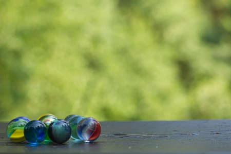 Colorful marbles on the garden wooden tableの写真素材
