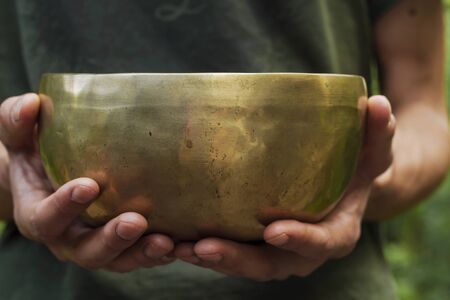 Hands holding a tibetan bowlの写真素材
