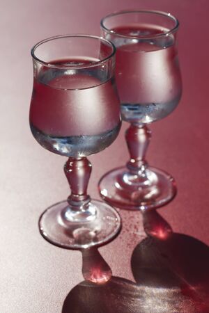 Two glasses of fresh water on red tableの写真素材
