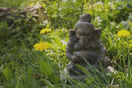 Lord Ganesh decorative stone statue in the green garden grassの写真素材