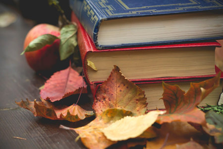 Old books among the autumnal fallen leaves