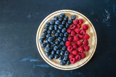 blueberries and raspberries on wooden dish