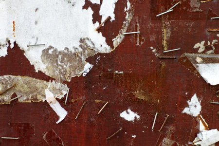 Old street bulletin board with rests of paper