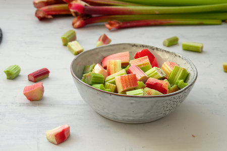 Chopped rhubarb stalks bowl on the kitchen tableの写真素材