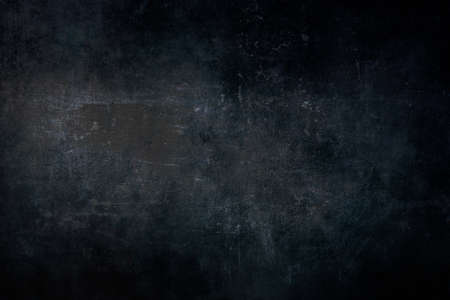 Dark blue scraped grungy wall background or texture with dark vignette bordersの写真素材
