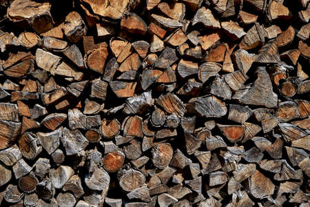 Dry chopped firewood stacked in a wood pile, hi res stock photoの写真素材