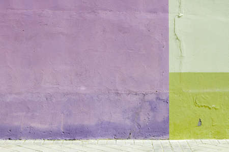 Viotet and green painted wall with tiled street floor, modern architecture detail, urban geometric abstract background or textureの写真素材