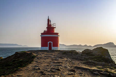 Old red lighthouse in Punta Robaleira and Islas Cies from Cabo Home, Rias Baixas, Galicia, Spainの写真素材