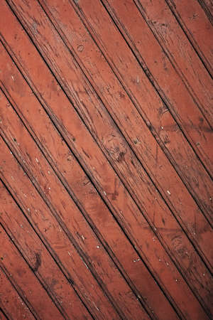 Old distressed red wooden wall with diagonal strips, rustic background or textureの写真素材