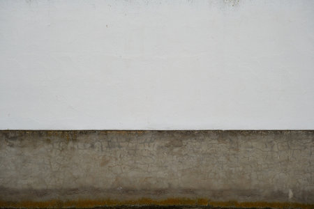 Old whitewashed lime wall with raw cement grey skirting board, traditional architecture in La Mancha, Spainの写真素材