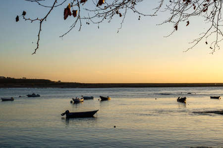 Small boats tied on the quay at sunsetの写真素材