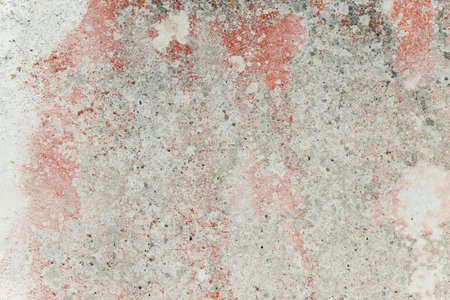 Old worn out red distressed cement wall with lichens, grunge texture or backgroundの写真素材
