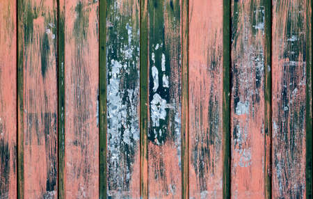 Old metallic shutter with red and green peeling paint, grunge background or textureの写真素材