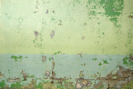 Old weathered concrete wall with green peeling paint, grunge background or textureの写真素材