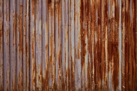 Old rusty metallic shutter with worn out peeling paint, grunge background or textureの写真素材