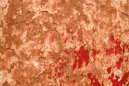 Old ruin wall with red peeling paint, grunge background or textureの写真素材