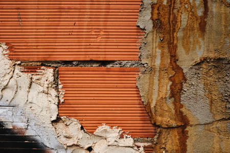 Detail of brick wall covered with cement stained with rust, architecture detail grunge background or textureの写真素材