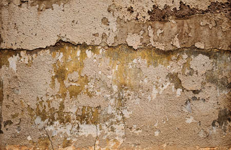 Old ruin wall with peeling plaster, grunge background or textureの写真素材