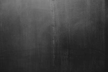 Dark gray plaster finish on concrete wall, grunge background or textureの写真素材