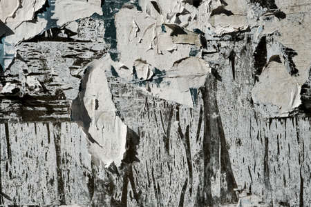 Worn out peeling posters on old weathered bulletin board, grunge background or textureの写真素材