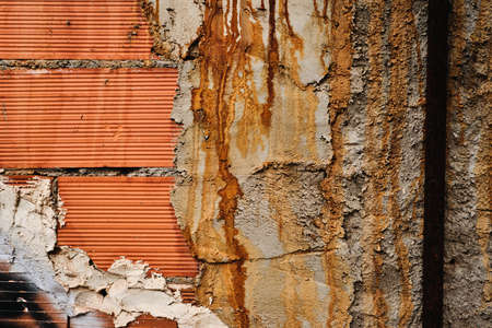 Detail of brick wall covered with cement stained with rust, architecture detail grunge background or textureの写真素材