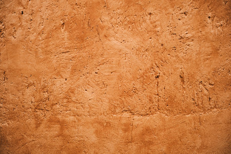 Terracotta colored plaster wall, rustic background or textureの写真素材