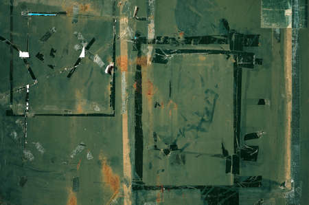 Old green painted metal sheet weathered and rusty with rests of adhesive tape, grunge background or textureの写真素材