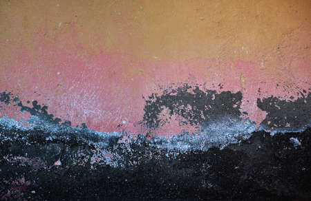 Old distressed wall with damp and worn out layers of pastel colors paint, grunge background or textureの写真素材