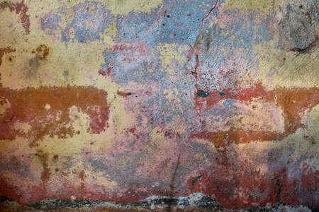 Old distressed wall with damp and worn out layers of pastel colors paint, grunge background or textureの写真素材