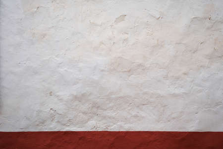 Old whitewashed lime wall with red skirting board, traditional architecture in La Mancha, Spainの写真素材