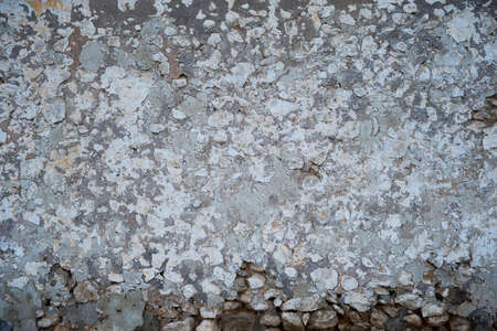 Old traditional limewashed stone wall with peeling plaster, white rustic background or textureの写真素材