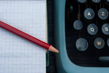 Vintage desk detail with blank note pad, pencil and vintage typewriperの写真素材