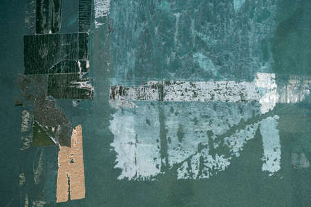Adhesive tape remainders over old green metal panel, grunge texture abstract backgroundの写真素材