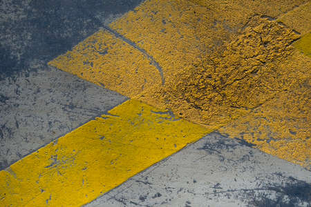 Reflective yellow bands painted on a parking lot pavement, road grunge texture, abstract detailの写真素材
