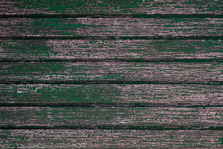 Old green painted wooden planks wall with weathered cracked paint making a craquelure pattern, grunge rustic textured backgroundの写真素材