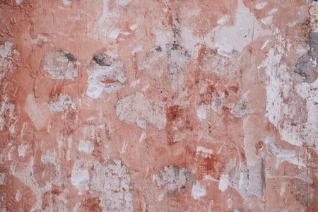 Detail of old pink wall refurbishing with scraps of removed plaster coating, grunge textured backgroundの写真素材