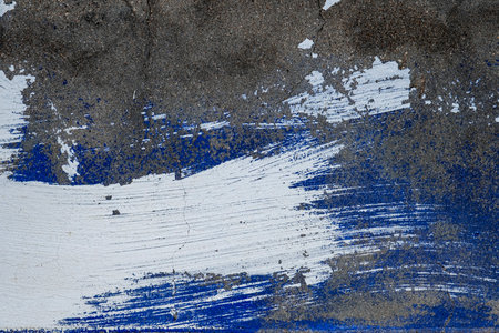 White paint stroke on old wall with worn out blue paint, abstract backgroundの写真素材