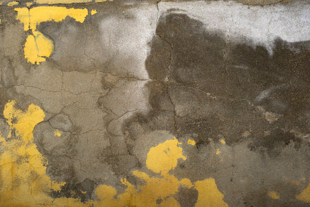 Detail of old cracked concrete wall with worn out yellow paint and moisture, grunge backgroundの写真素材