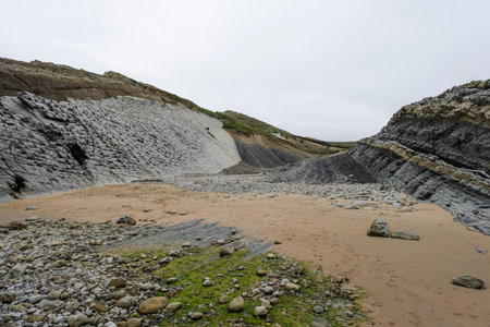 Coastal erosion in Pedruquios beach, sedimentary rocks and landforms eroded by wave action in the cliffs and coastline by the Cantabrian Sea, Costa Quebrada, Liencres, Northern Spainの写真素材