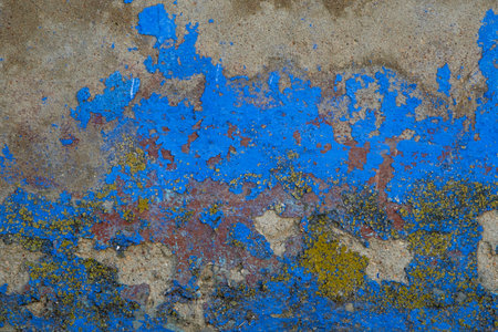 Detail of old blue painted wall texture with scraps of flaking paint and yellow lichensの写真素材