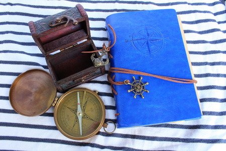 A logbook with a compass and a pirate chest on a seabedの写真素材