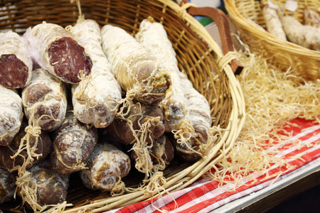 group of dry sausages stacked in a wicker basket