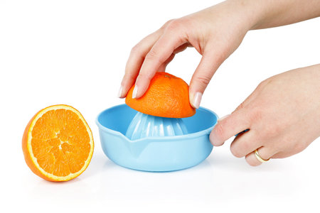 Close up of female hands squeezing orange