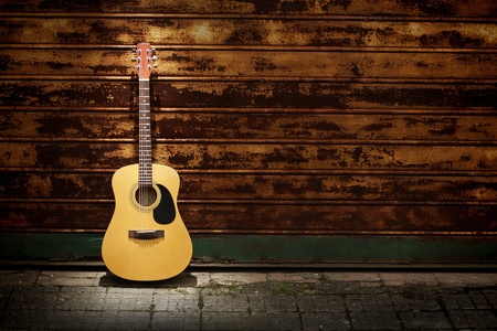Acoustic guitar leaning  on rusty  gatesの写真素材