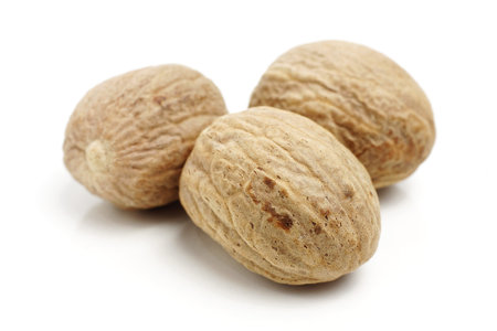Three nutmegs isolated on whiteの写真素材