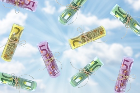 Falling rolled euro banknotes against the skyの写真素材